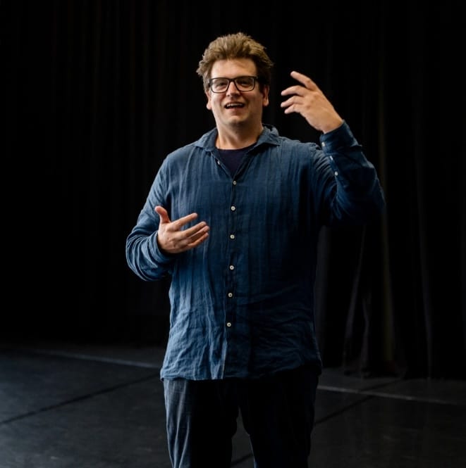 Christoph Galette auf der Bühne mit erhobener Hand