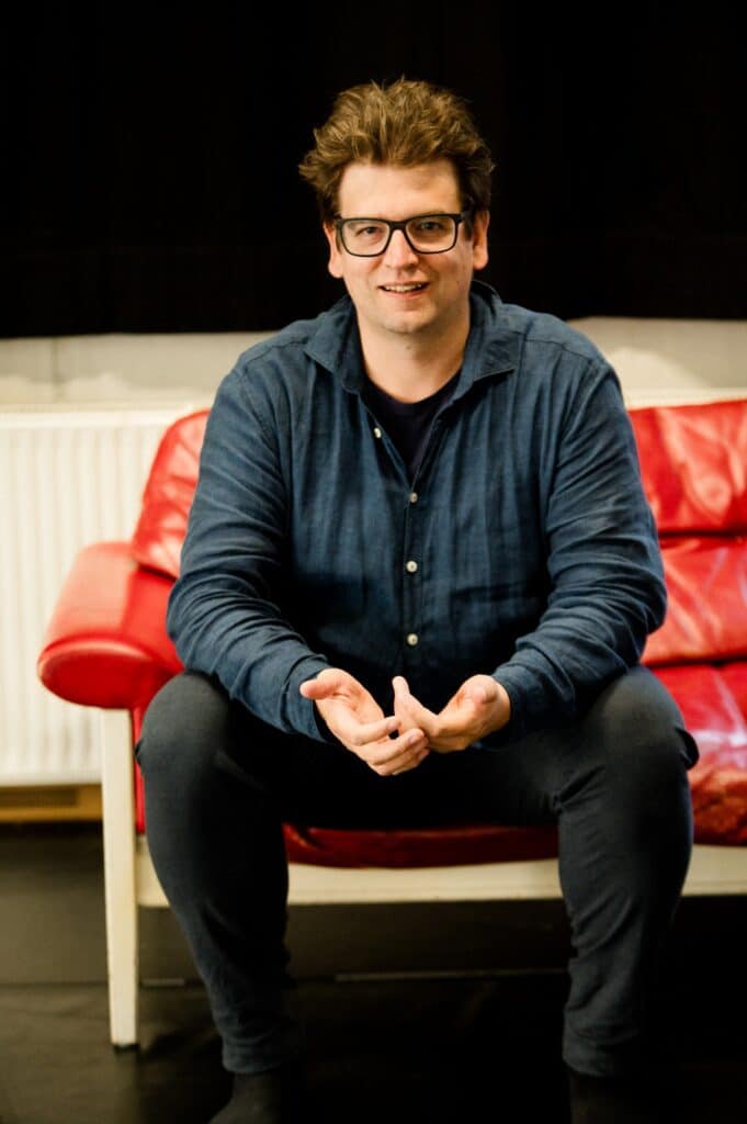 Christoph Galette auf einem roten Sofa