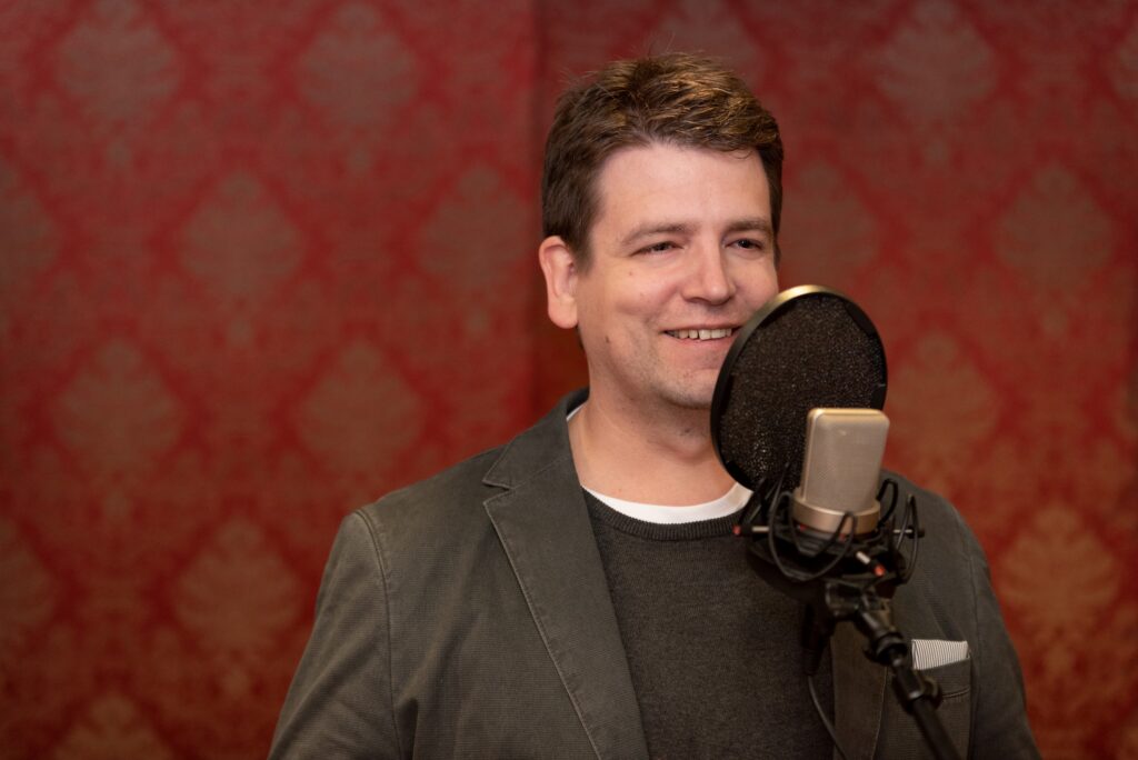 Christoph Galette als Sprecher am Mikrofon im Tonstudio